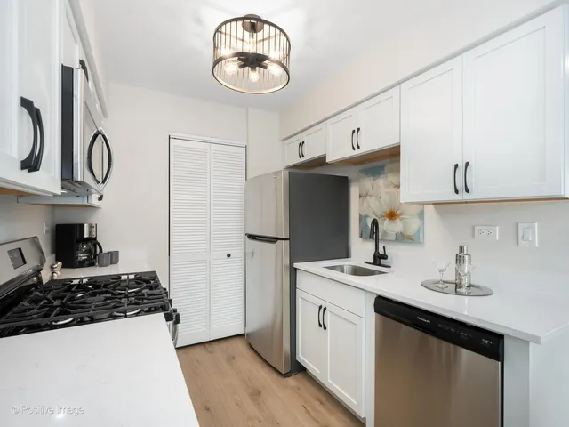 a kitchen with stainless steel appliances a sink a stove and refrigerator