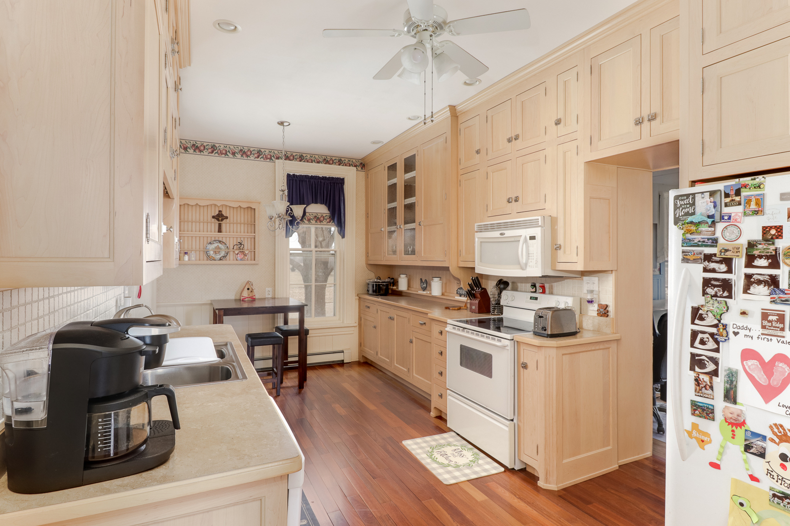 367 Horner Road Armington, IL 61721 - Photo 20 of 50 a kitchen with stainless steel appliances granite countertop a stove a sink dishwasher and white cabinets with wooden floor