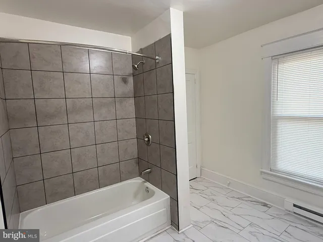 a bathroom with a bathtub and shower
