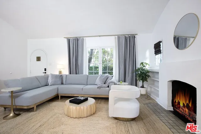 a living room with furniture a window and a fireplace