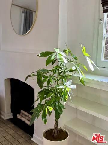 a living room with furniture a fireplace a flat screen tv and a large window