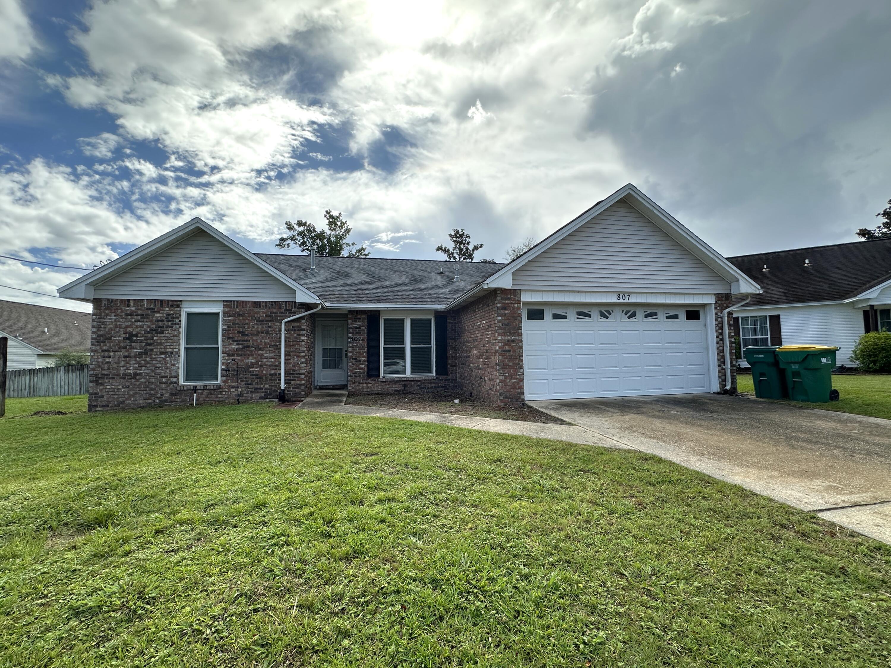 807 Sparkleberry Cove Niceville, FL 32578 - Photo 1 of 1 a view of a yard in front of a house with large garden