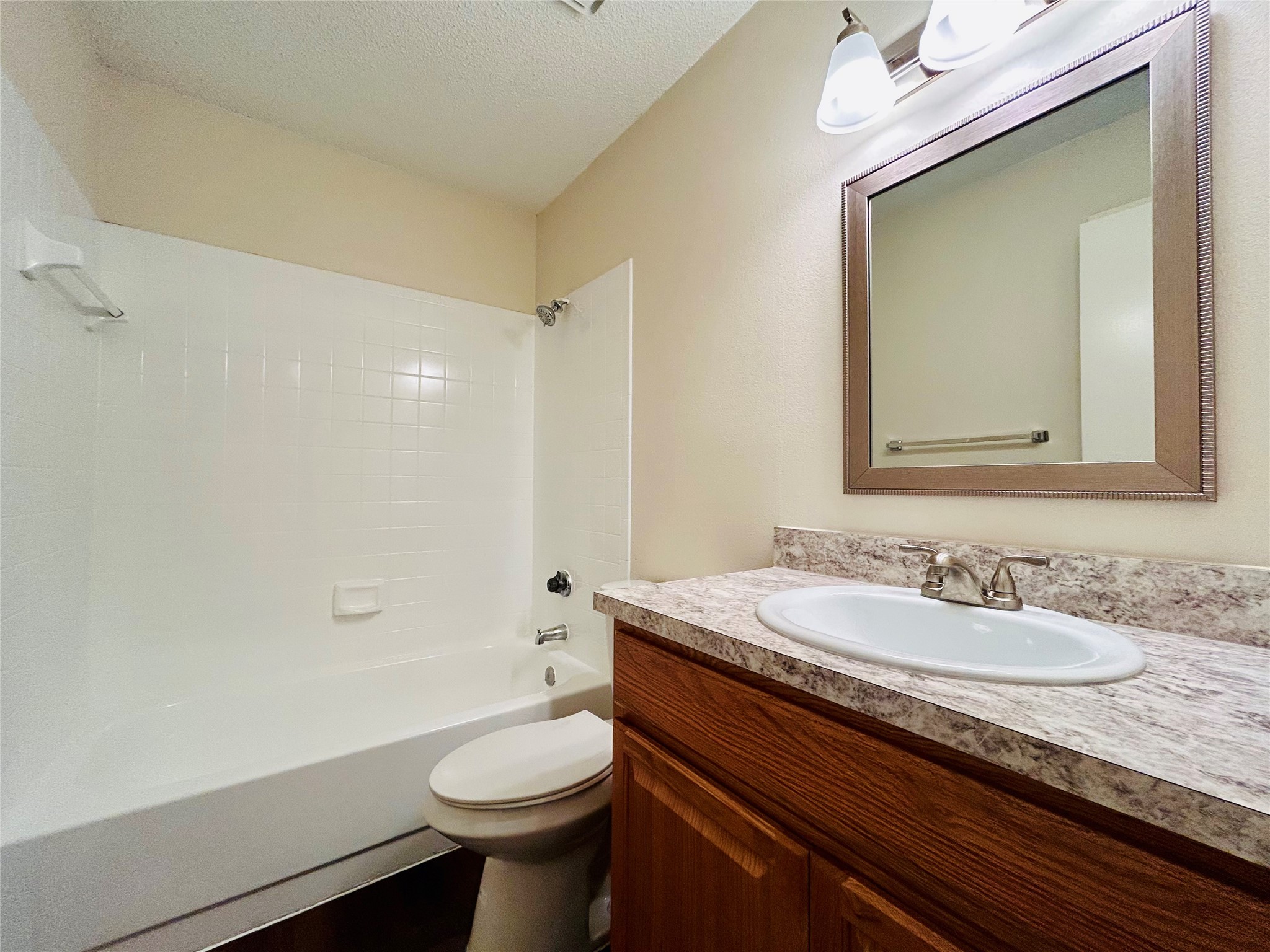 8902 Schick Road, Unit B Austin, TX 78729 - Photo 12 of 20 a bathroom with a sink a toilet and shower
