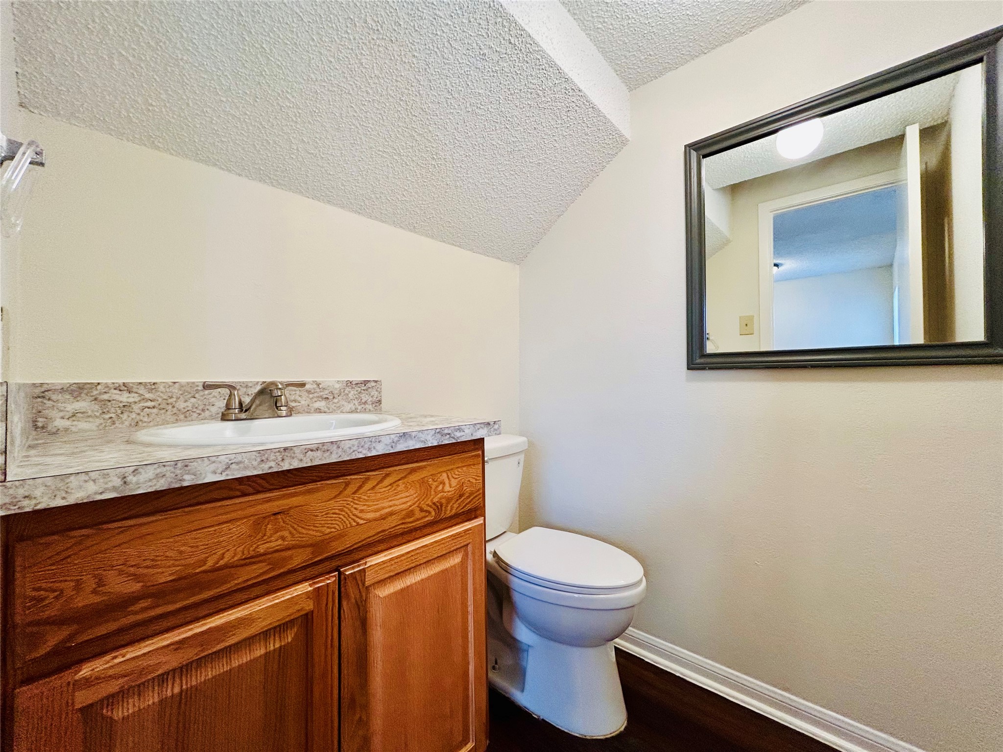 8902 Schick Road, Unit B Austin, TX 78729 - Photo 16 of 20 a bathroom with a toilet sink and mirror