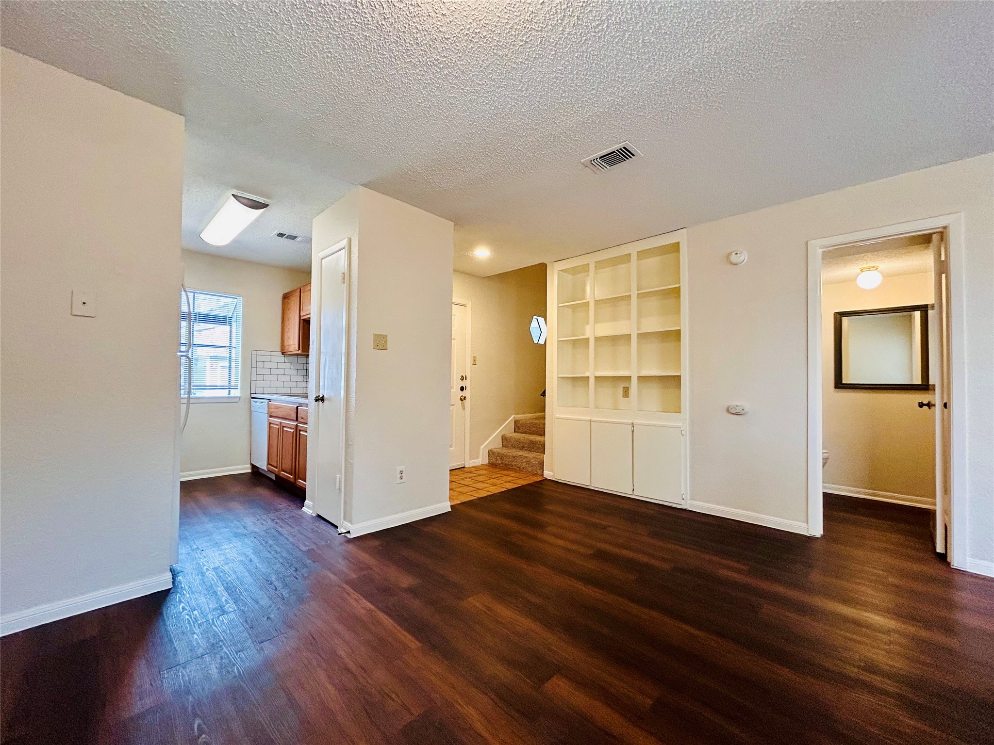 8902 Schick Road, Unit B Austin, TX 78729 - Photo 7 of 20 a view of an empty room with wooden floor and a window