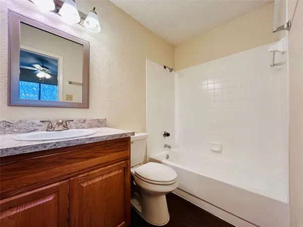 a bathroom with a granite countertop sink toilet a large mirror and shower