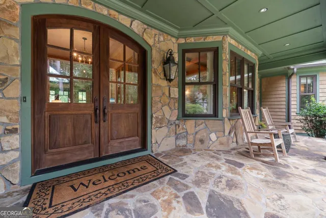 a living room with furniture a chandelier and a large window
