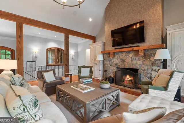 a living room with furniture a flat screen tv and a fireplace