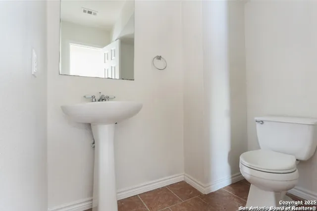 a bathroom with a sink toilet and a mirror