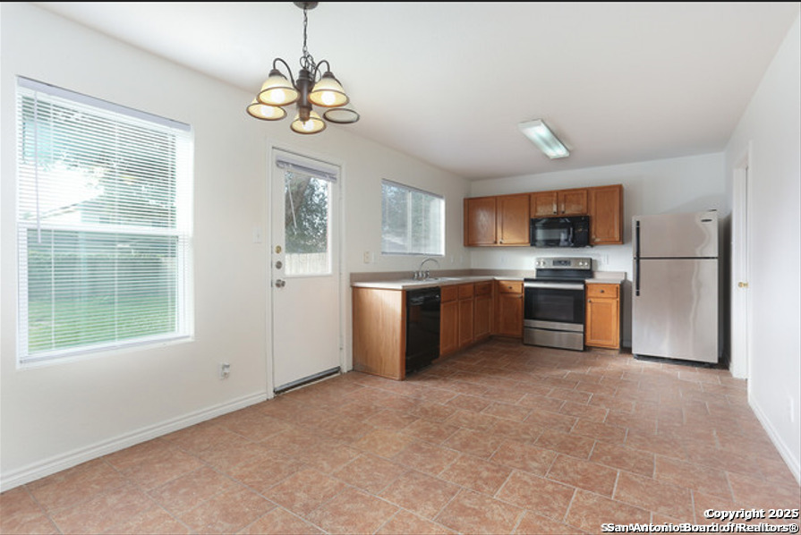 3954 Regal Rose San Antonio, TX 78259 - Photo 6 of 18 a kitchen with a refrigerator a stove top oven a sink and a window