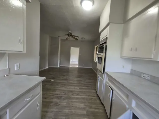 a view of a kitchen cabinets a sink and dishwasher wooden floor