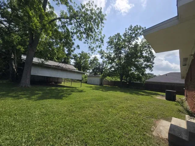 a view of a backyard with large trees