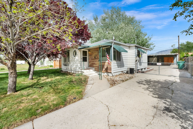 4635 Box Elder Street Murray, UT 84107 - Photo 2 of 21 View of front of house featuring a front lawn, an outdoor structure, and driveway