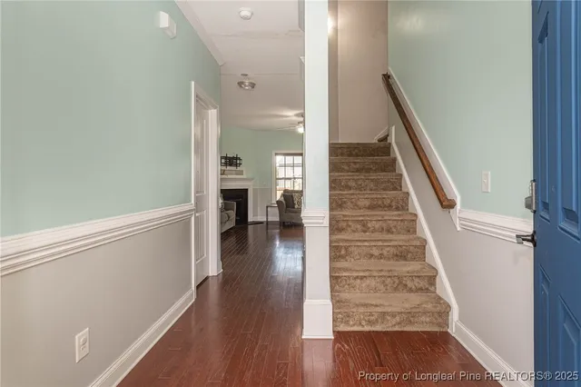 a view of a hallway with wooden floor and staircase