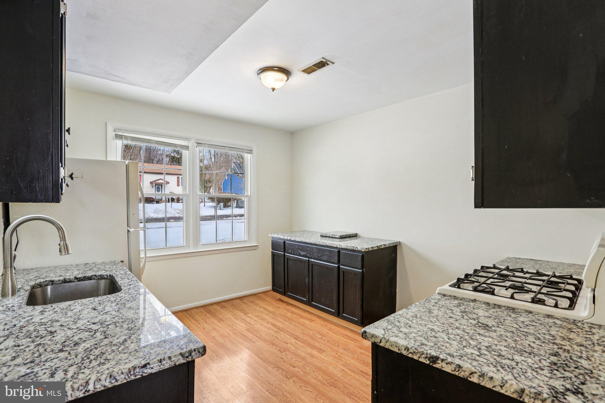 117 West Village Road Elkton, MD 21921 - Photo 8 of 37 a kitchen with granite countertop a stove and a refrigerator