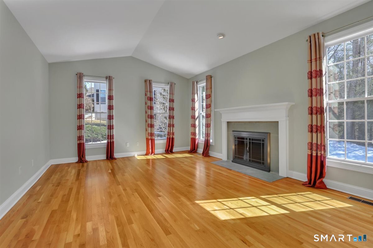 25 Fenwick Drive Avon, CT 06001 - Photo 6 of 40 a view of empty room with wooden floor and fireplace