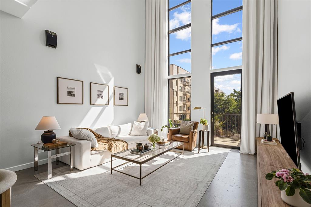 a living room with furniture a flat screen tv and a floor to ceiling window