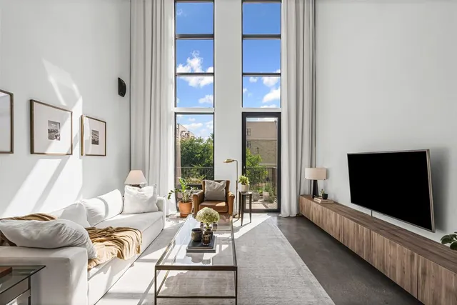 a living room with furniture a flat screen tv and a floor to ceiling window