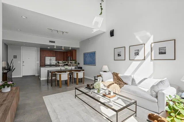 a living room with furniture kitchen view and a table