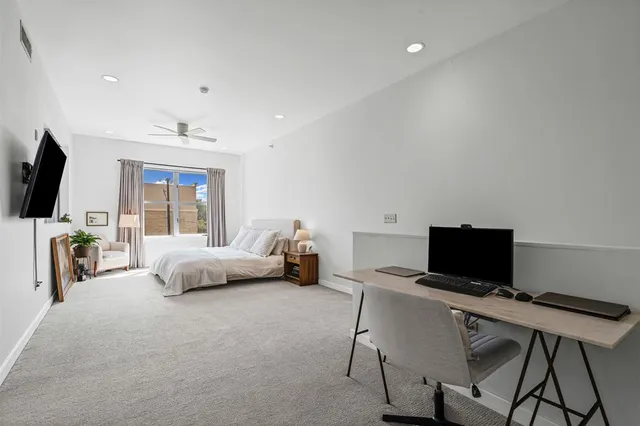 a bedroom with furniture and a flat screen tv