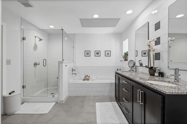a bathroom with a granite countertop sink mirror bathtub and shower