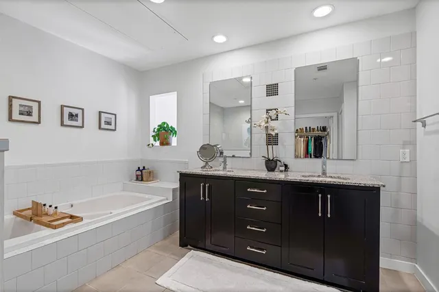 a bathroom with a tub sink and mirror