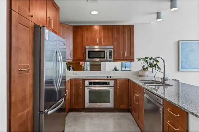 a kitchen with stainless steel appliances granite countertop a refrigerator stove and sink