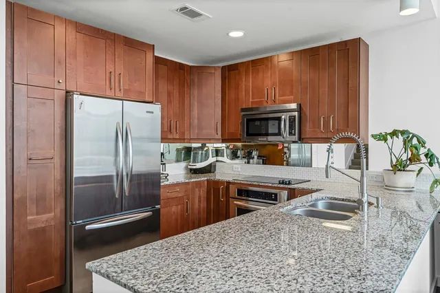 a kitchen with stainless steel appliances granite countertop a refrigerator stove top oven a sink and dishwasher