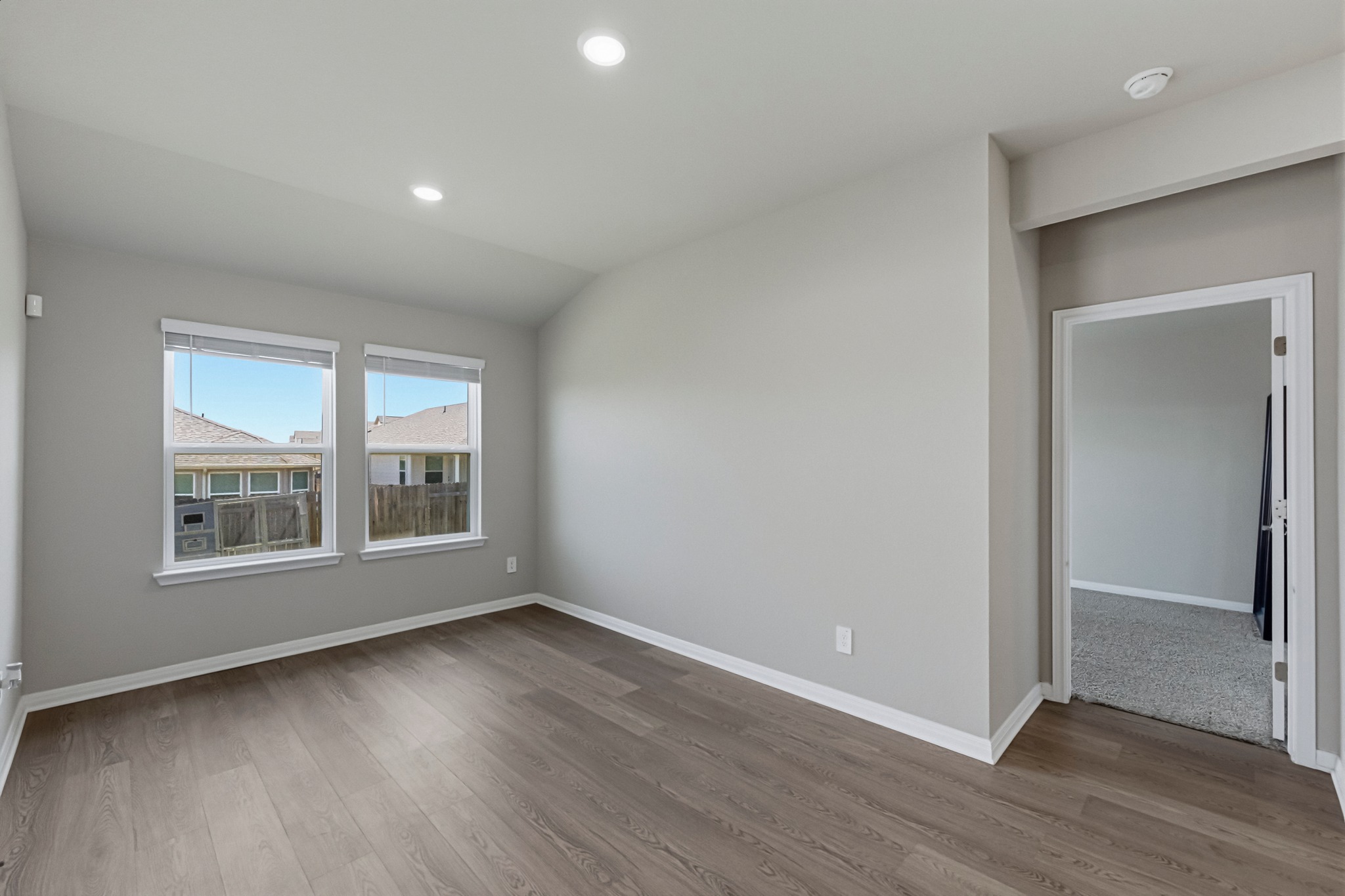 12309 Dairywork Road Buda, TX 78610 - Photo 9 of 29 Empty room featuring vaulted ceiling, recessed lighting, and light wood finished floors