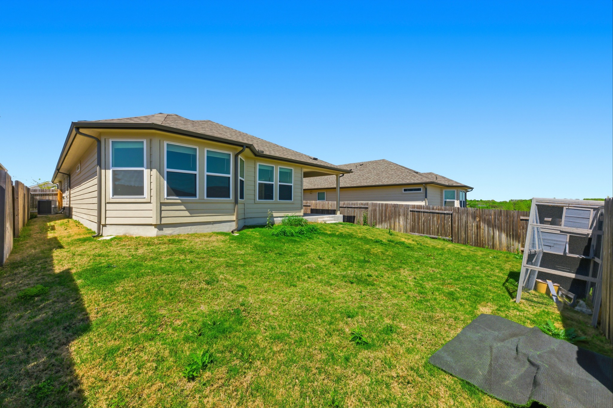 12309 Dairywork Road Buda, TX 78610 - Photo 25 of 29 Rear view of house featuring a fenced backyard, exterior structure, and an outdoor structure