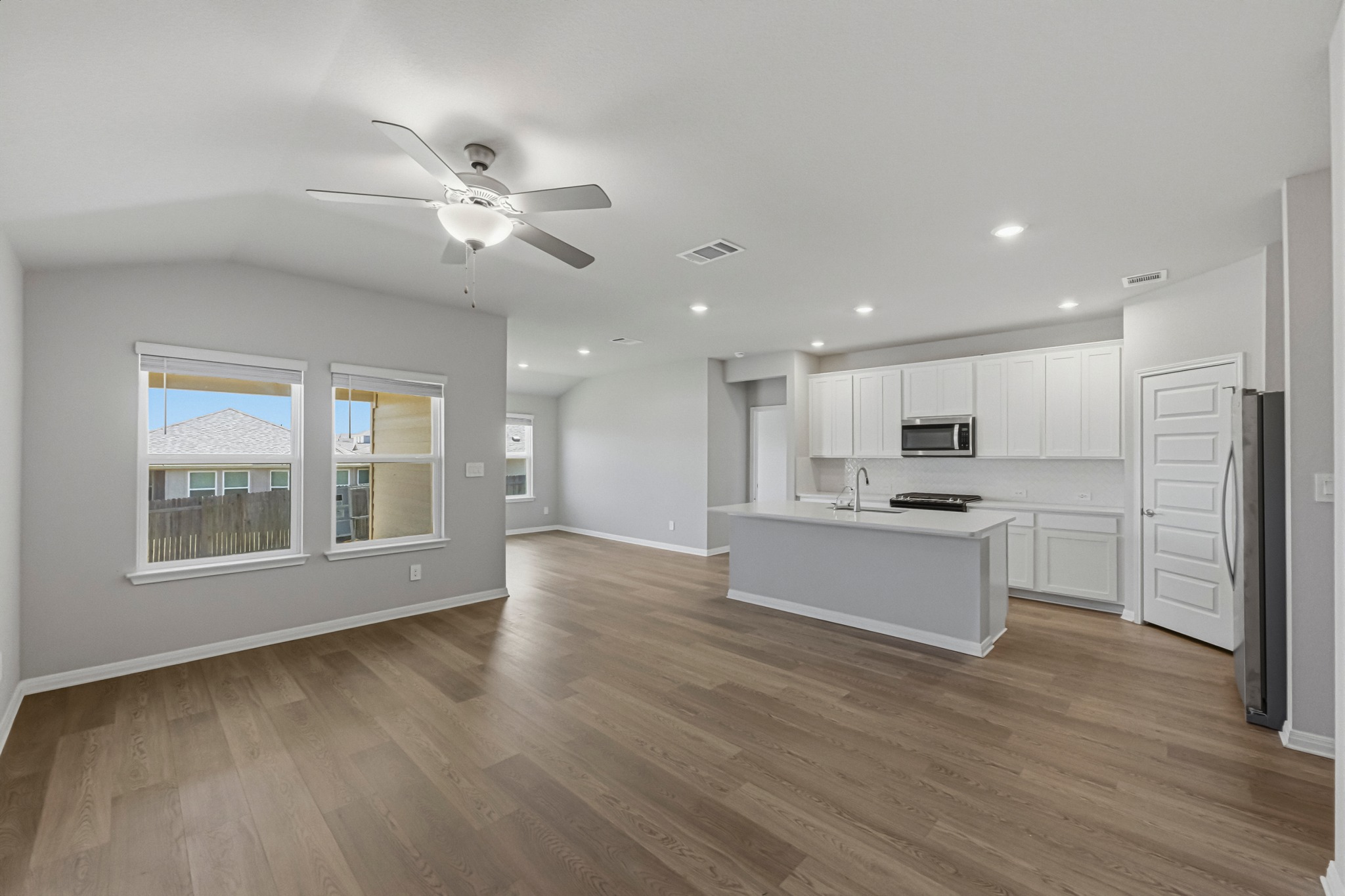 12309 Dairywork Road Buda, TX 78610 - Photo 27 of 29 Kitchen featuring open floor plan, a ceiling fan, white cabinets, a center island with sink, and stainless steel appliances
