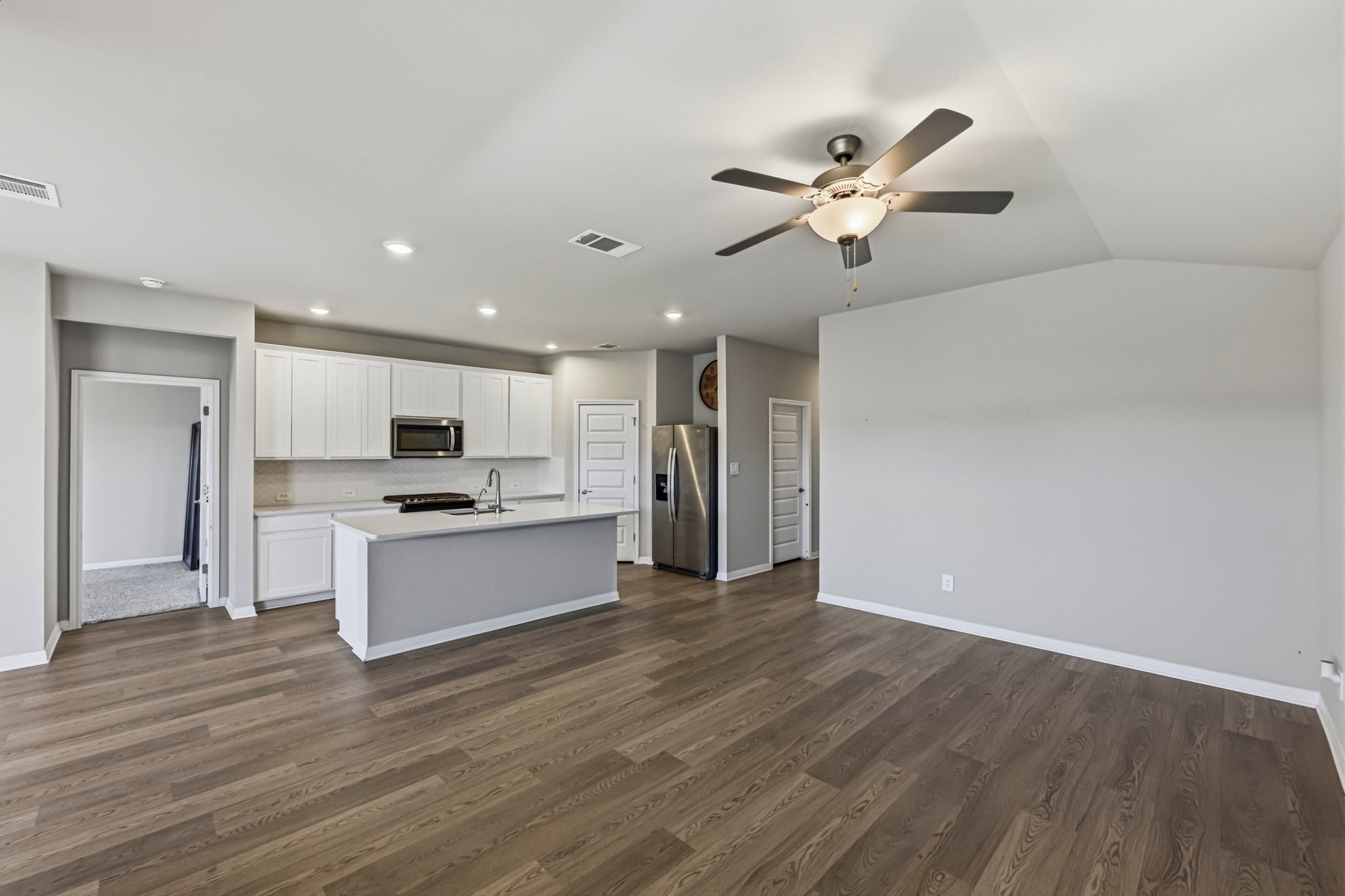 12309 Dairywork Road Buda, TX 78610 - Photo 28 of 29 Kitchen with open floor plan, light countertops, stainless steel appliances, white cabinetry, and a kitchen island with sink