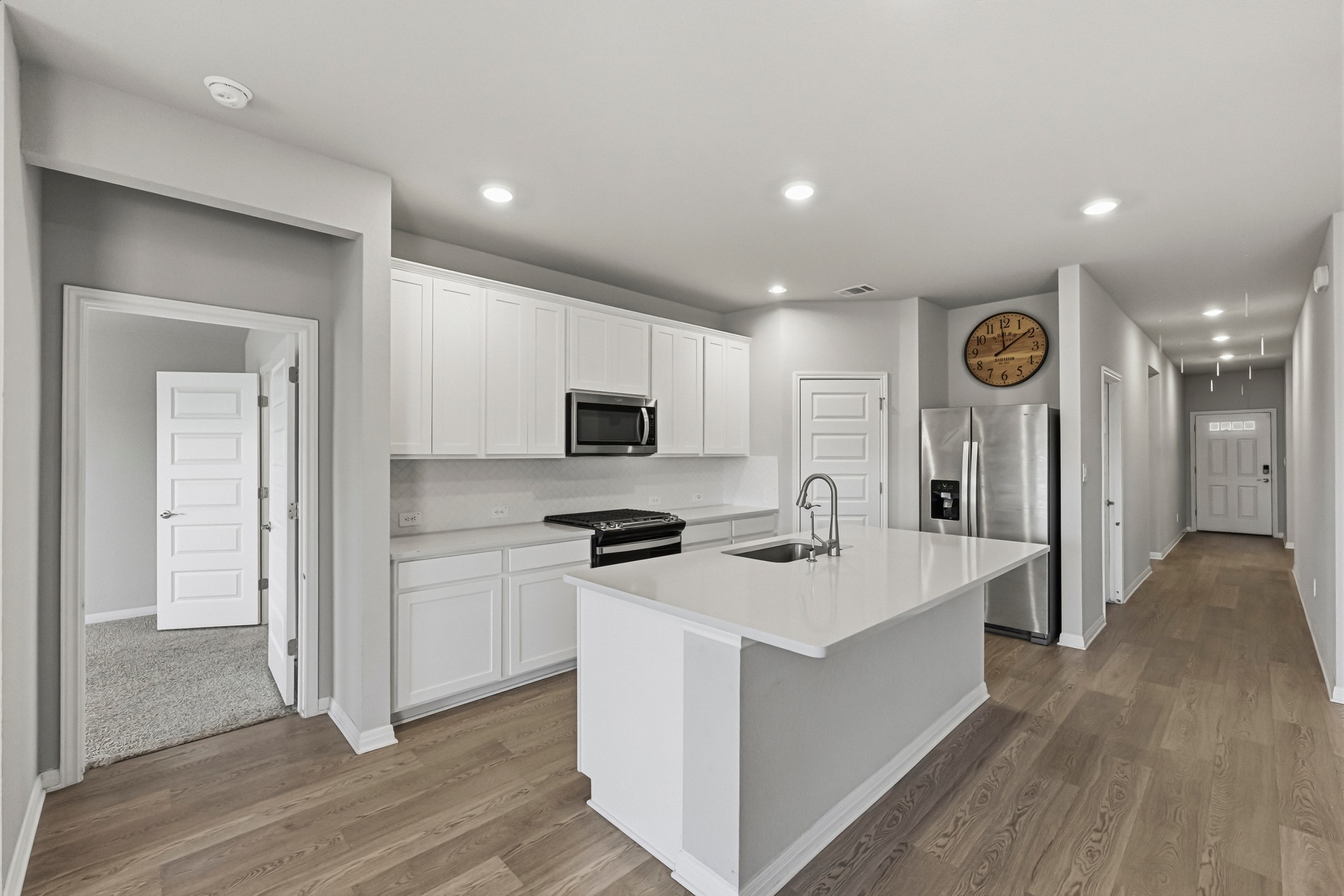 12309 Dairywork Road Buda, TX 78610 - Photo 5 of 29 Kitchen with white cabinets, stainless steel appliances, a kitchen island with sink, dark wood-style floors, and recessed lighting