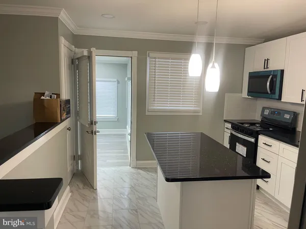 a kitchen with a refrigerator and a stove top oven