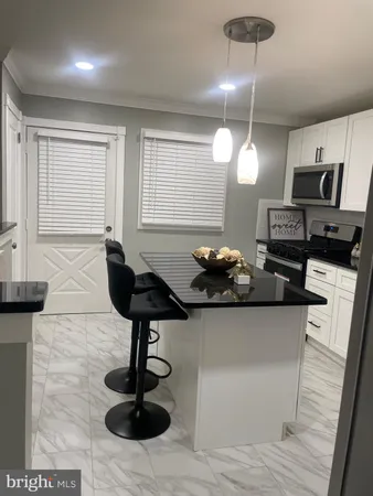 a kitchen with stainless steel appliances a sink a stove and a wooden floor