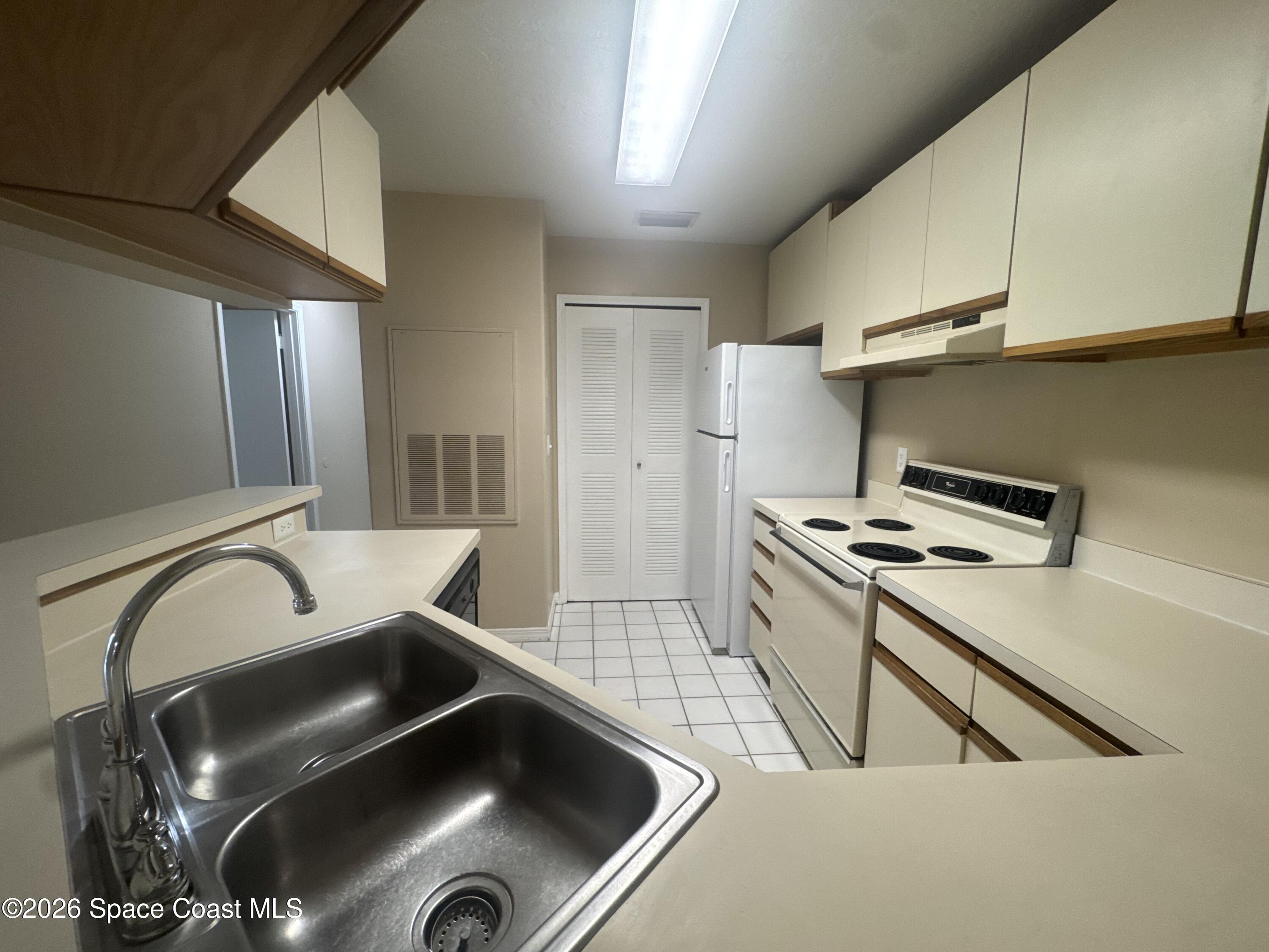 7667 North Wickham Road, Unit 1107 Melbourne, FL 32940 - Photo 5 of 19 a kitchen with a stove and a sink