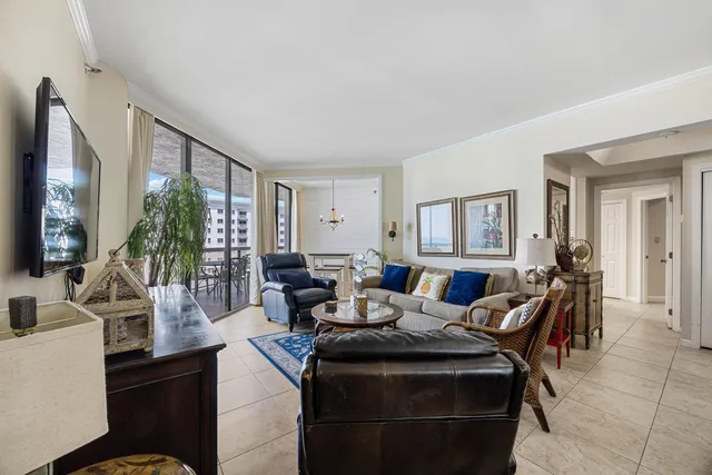 a living room with furniture a large window and potted plants