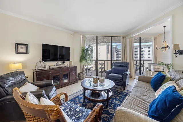 a living room with furniture a flat screen tv and a large window