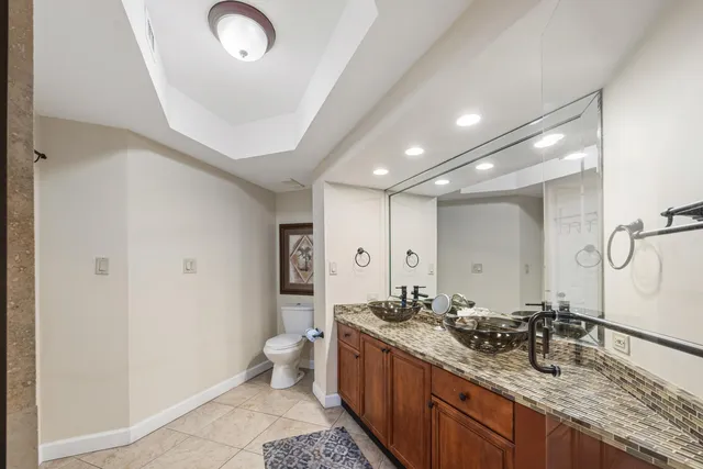 a bathroom with a double vanity sink a toilet and a mirror