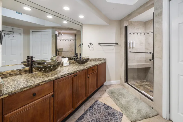 a bathroom with a granite countertop sink mirror and shower