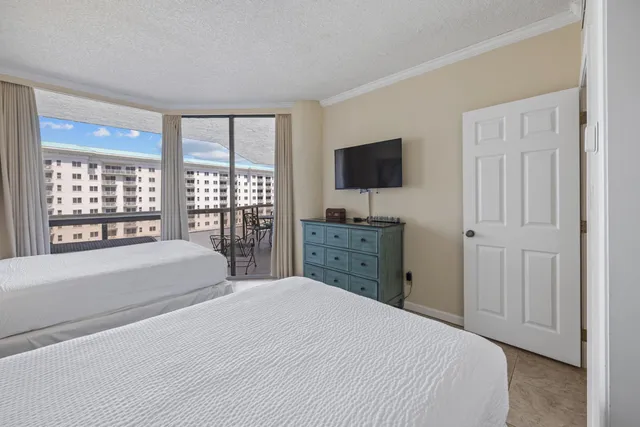 a bedroom with a large bed and a flat tv screen next to a window