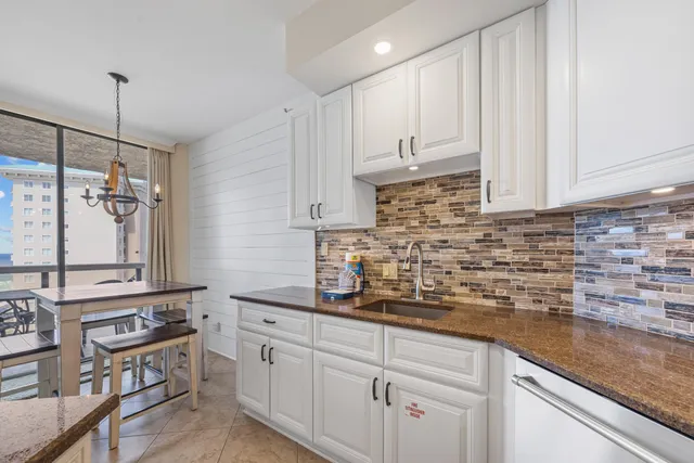 a kitchen with stainless steel appliances granite countertop a sink a stove and cabinets