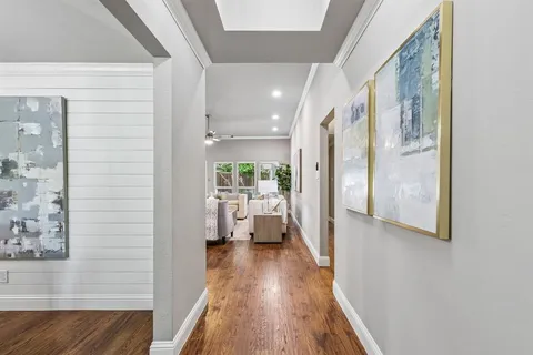 a view of a hallway with wooden floor and staircase