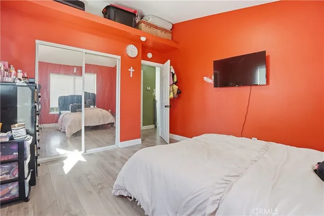 a bedroom with a bed and flat tv screen on dresser