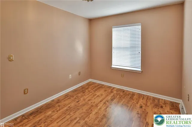 a view of a livingroom with wooden floor and a large window