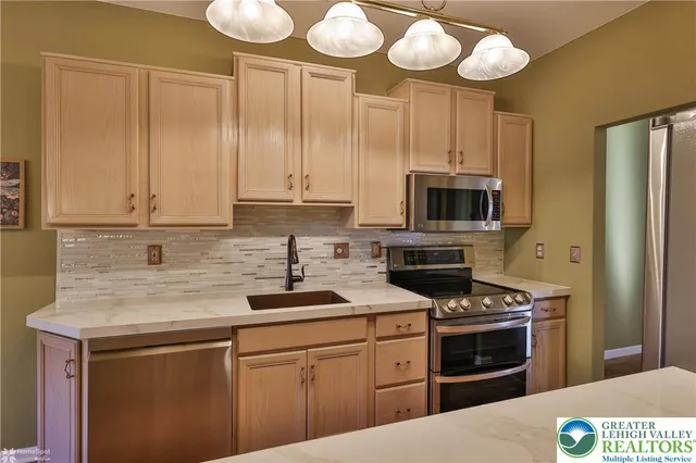 a kitchen with stainless steel appliances granite countertop a stove and a microwave