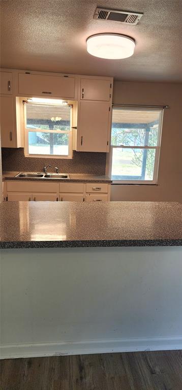 2016 Gavin Road Tool, TX 75143 - Photo 14 of 26 Vinyl flooring, white cabinetry, dark speckled countertops, and a double-basin sink