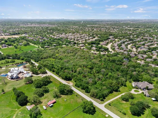 an aerial view of residential houses with outdoor space and trees