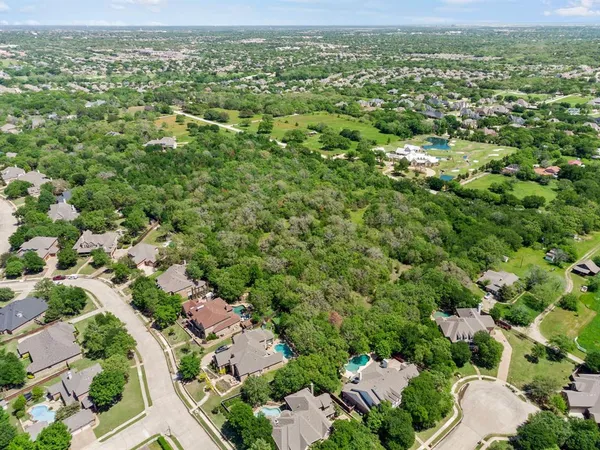 an aerial view of a houses with a lush green hillside
