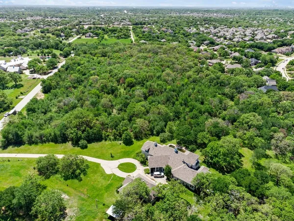 an aerial view of residential houses with outdoor space and trees